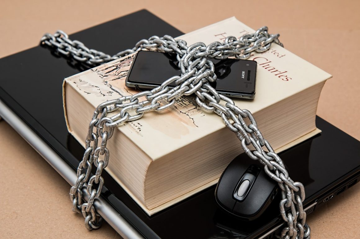 chains around computer, book, and phone