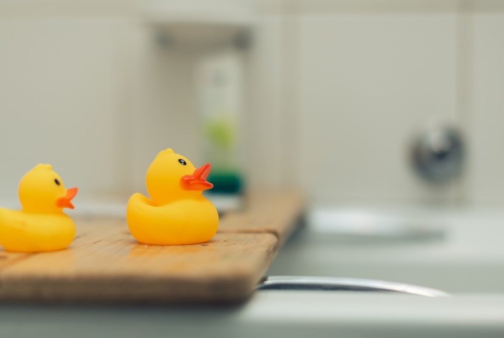 two plastic ducks and bathtub