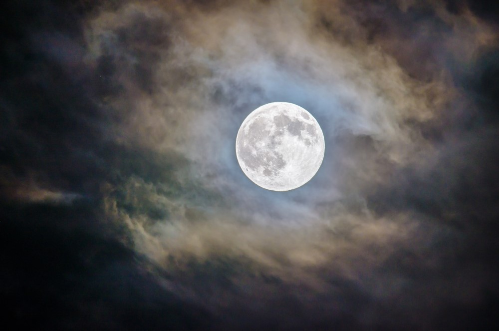 full moon surrounded by clouds